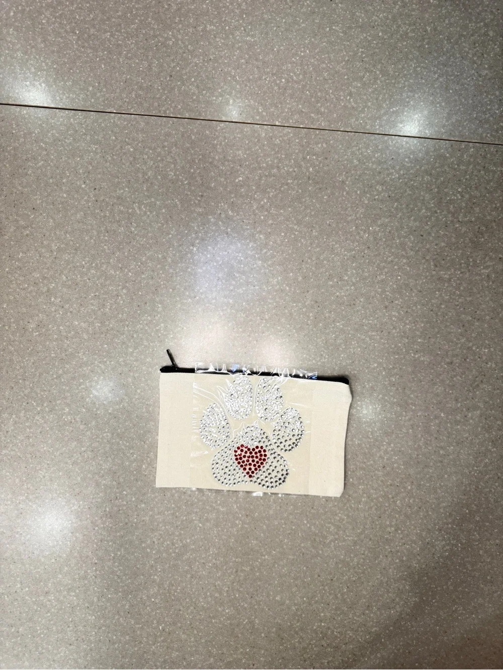 Cosmetic bag with crystal dog paw print.